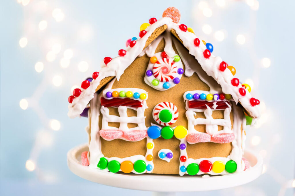 Festive gingerbread house with colorful candy decorations and holiday lights.