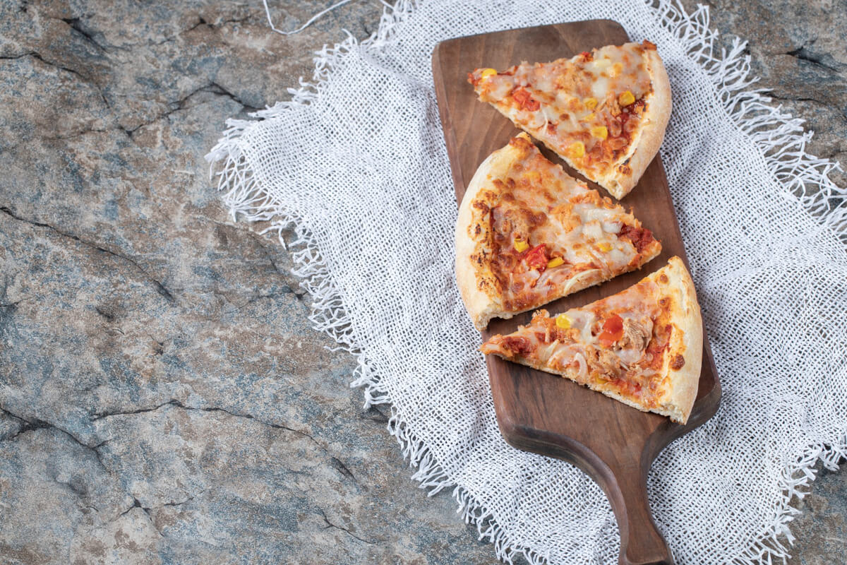 Keto-friendly canned chicken pizza crust topped with melted cheese and fresh basil.