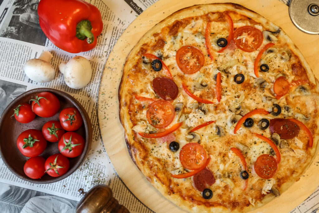 Freshly baked chicken crust pizza with colorful vegetables and melted cheese, ideal for low-carb and keto diets.