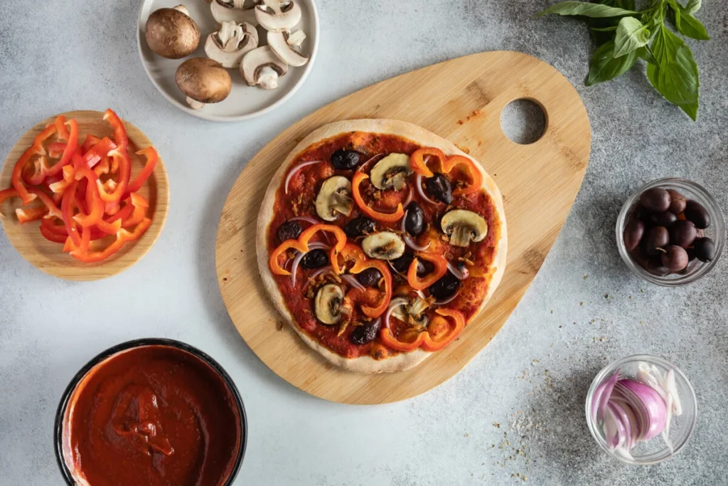 A whole pizza with a crispy golden crust and fresh toppings on a rustic board.