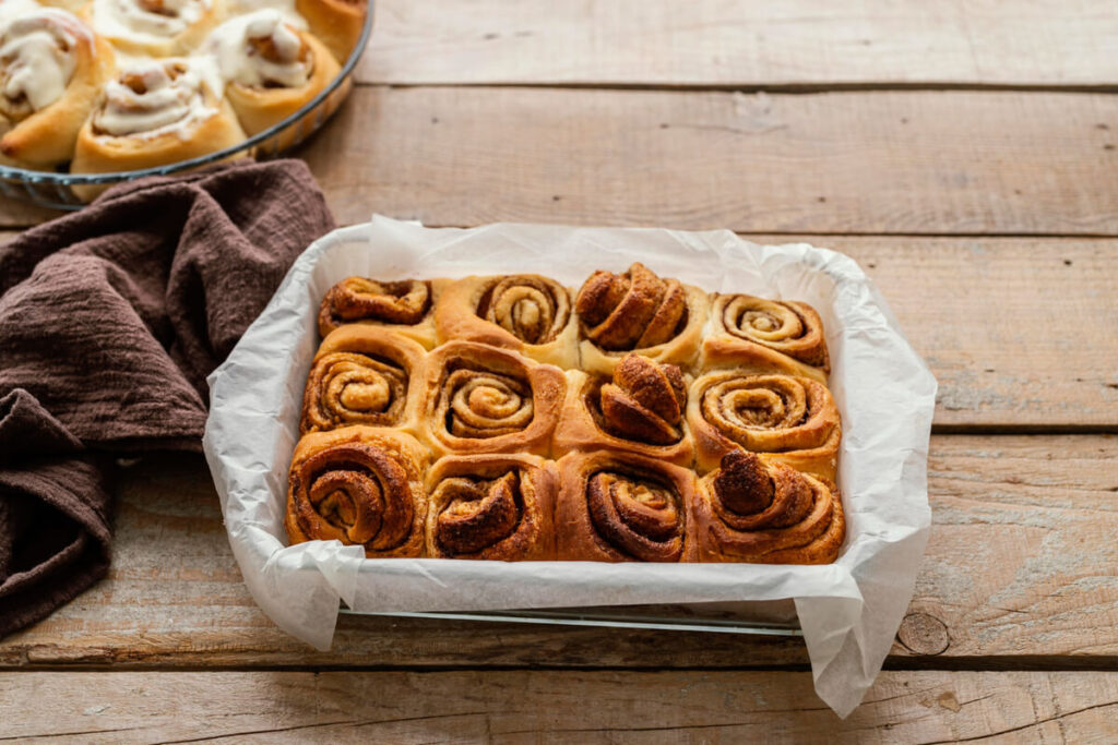 A golden-baked croissant French toast casserole in a white dish.