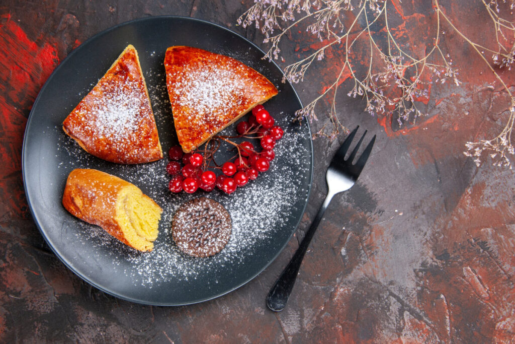 Golden croissant French toast topped with berries, syrup, and powdered sugar on a breakfast plate.