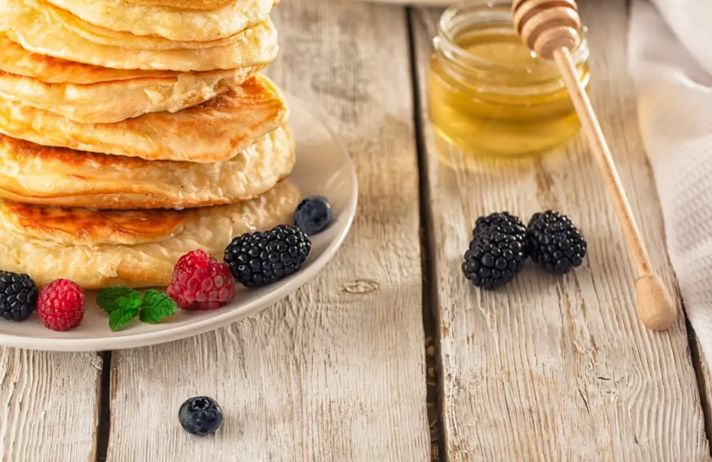 Dairy-free pancakes topped with fresh berries and maple syrup.