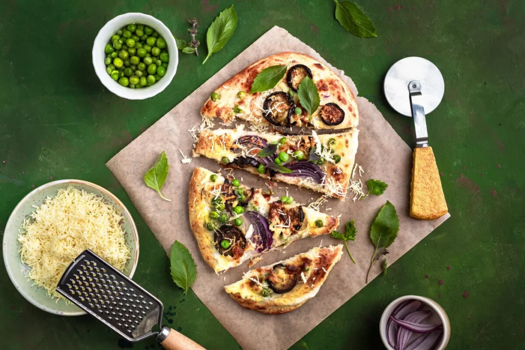 Golden cauliflower pizza crust with fresh herbs and raw ingredients on a rustic table.