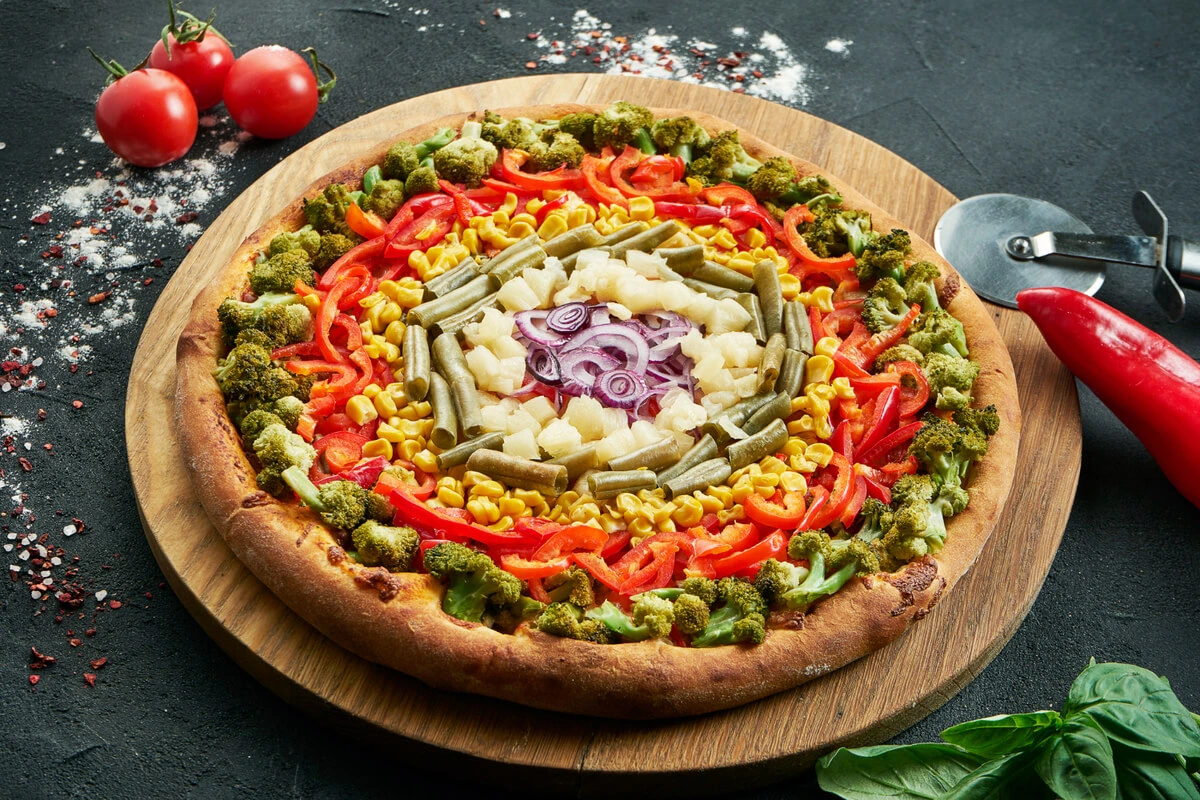 A whole healthy pizza with a cauliflower crust and fresh vegetable toppings.