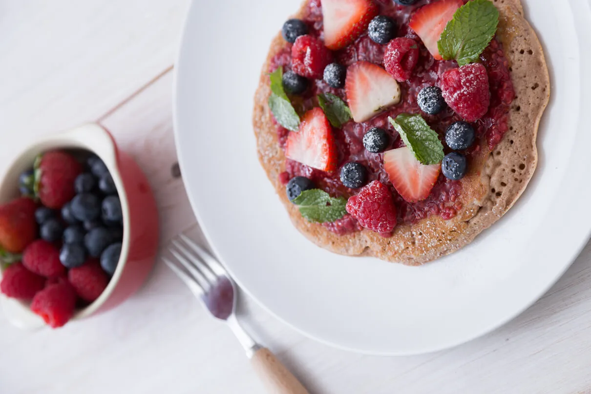 Healthy fluffy pancakes with fresh fruit and honey