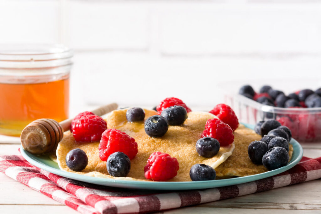 A stack of healthy whole-grain pancakes topped with fresh berries