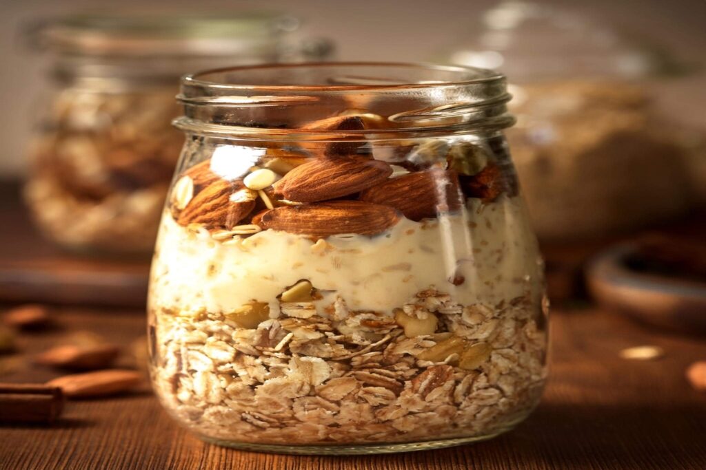 Mason jar of overnight oats with almond milk, bananas, and nuts, highlighting easy vegan breakfast recipe ideas.