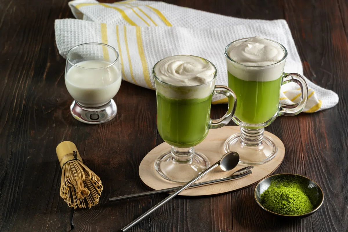 Hot and iced Starbucks Matcha Latte in a cozy café setting.